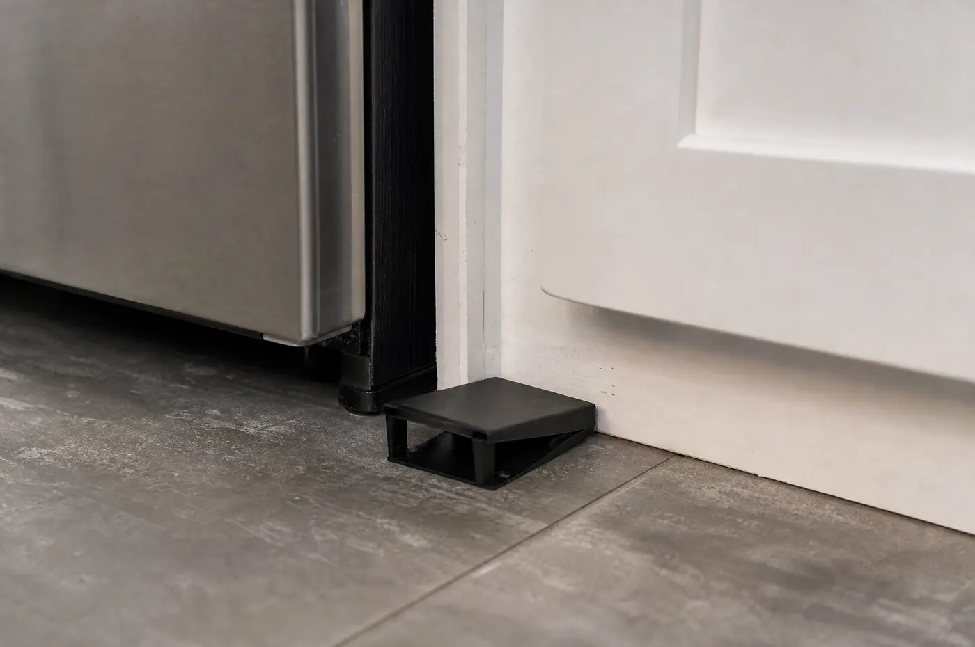 Small monitoring trap placed beside a kitchen appliance after a roach treatment