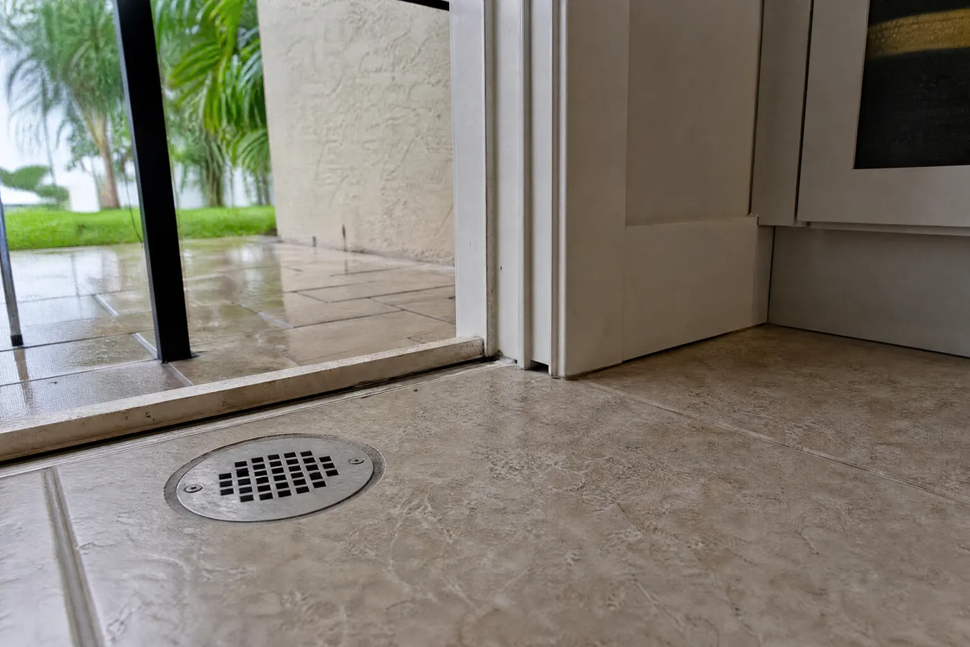Floor drain and narrow door threshold gap showing two common entry routes for an outdoor cockroach
